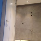 De badkamer wordt afgewerkt met betonstuc / betoncire